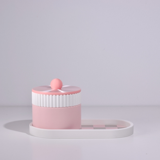 Pink and white cylindrical container with a lid on a light gray background