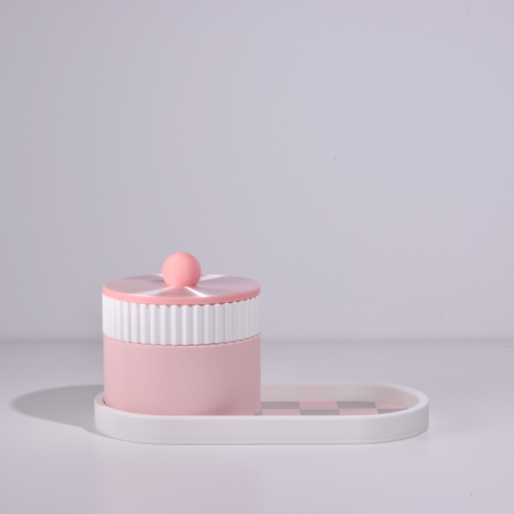 Pink and white cylindrical container with a lid on a light gray background