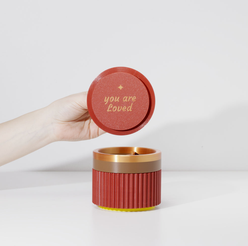 Lifting the lid of a burgundy MiniStack to show the hidden 'you are loved' affirmation